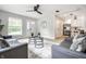 Bright living room featuring neutral walls, modern furniture, large windows, ceiling fan, and stylish decor at 3818 Fetlock Dr, Indianapolis, IN 46227