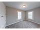 Bedroom with neutral walls, gray carpet, two windows, and a door to the hallway at 418 Eastern Ave, Indianapolis, IN 46201