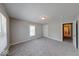 Well-lit bedroom featuring neutral walls, gray carpet, a window, and a door to the hallway at 418 Eastern Ave, Indianapolis, IN 46201