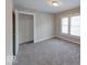 Cozy bedroom with neutral walls, gray carpet, two windows, and a closet for storage at 418 Eastern Ave, Indianapolis, IN 46201