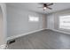 An airy room with modern gray flooring, a ceiling fan, and bright windows enhancing natural light at 418 Eastern Ave, Indianapolis, IN 46201