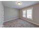 A cozy bedroom features neutral walls, new carpet, and natural light from the window at 420 Eastern Ave, Indianapolis, IN 46201