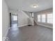 Open-concept living room with gray walls, vinyl floors, staircase, and lots of natural light at 420 Eastern Ave, Indianapolis, IN 46201