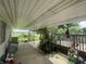 Covered back porch with view of open field, bench seating and lattice shadow detail at 4363 Roosevelt Dr, Columbus, IN 47201