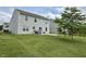 This home features a large backyard with healthy green lawn and a concrete patio at 4925 Chip Shot Ln, Indianapolis, IN 46235
