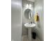 The half bathroom features a pedestal sink, a round mirror, overhead lighting and a yellow hand towel at 4925 Chip Shot Ln, Indianapolis, IN 46235