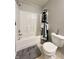 Standard bathroom featuring a shower-tub combo with black and gray curtains and a white toilet at 4925 Chip Shot Ln, Indianapolis, IN 46235