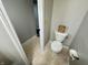 A cozy half bathroom features a toilet, toilet paper holder, and a decorative wooden block at 4925 Chip Shot Ln, Indianapolis, IN 46235