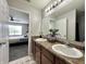 A well-lit bathroom features double sinks, a large mirror and modern finishes and accents at 4925 Chip Shot Ln, Indianapolis, IN 46235