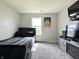 Bedroom with a TV, bed, light gray carpet, window, and entertainment stand at 4925 Chip Shot Ln, Indianapolis, IN 46235