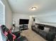 Bonus room features large grey couch, desk, TV and gaming chair at 4925 Chip Shot Ln, Indianapolis, IN 46235
