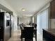 Dining area featuring a dark wooden table, set for a meal, with a modern kitchen nearby at 4925 Chip Shot Ln, Indianapolis, IN 46235
