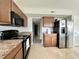 Efficient kitchen features wooden cabinets and stainless steel refrigerator at 4925 Chip Shot Ln, Indianapolis, IN 46235