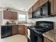 Updated kitchen with wood cabinets, modern black appliances, and laminate countertop at 4925 Chip Shot Ln, Indianapolis, IN 46235