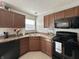 Spacious kitchen features wooden cabinets, laminate counters and modern black appliances at 4925 Chip Shot Ln, Indianapolis, IN 46235