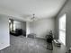 Spacious living area with gray carpeting and a gray storage chest, seamlessly connecting to dining area at 4925 Chip Shot Ln, Indianapolis, IN 46235