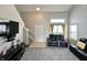 Cozy living room features carpet, staircase, front door, and sleek black entertainment center at 4925 Chip Shot Ln, Indianapolis, IN 46235
