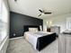 A bright main bedroom features a bed, neutral walls, ceiling fan, carpet floors and modern dressers at 4925 Chip Shot Ln, Indianapolis, IN 46235