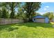 Fenced backyard with a lush green lawn and a detached garage at 552 Woodruff Pl W Dr, Indianapolis, IN 46201