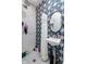 Stylish bathroom featuring star-patterned tiles, a shower, and a round mirror above the sink at 552 Woodruff Pl W Dr, Indianapolis, IN 46201