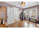 Bedroom with hardwood floors, natural lighting from two windows, and a door leading to the hallway at 552 Woodruff Pl W Dr, Indianapolis, IN 46201