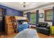 Stylish bedroom with a wooden bunk bed, blue accent wall, and cozy seating area at 552 Woodruff Pl W Dr, Indianapolis, IN 46201