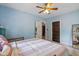 Cozy bedroom with light blue walls, a ceiling fan, and a comfortable bed with a striped blanket at 552 Woodruff Pl W Dr, Indianapolis, IN 46201