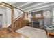 Cozy living room with exposed brick fireplace, decorative mantle, and hardwood floors leading to the stairs at 552 Woodruff Pl W Dr, Indianapolis, IN 46201