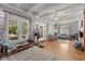 Bright living room with hardwood floors, coffered ceilings, and large windows with decorative curtains at 552 Woodruff Pl W Dr, Indianapolis, IN 46201