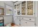 Charming butler's pantry with built-in cabinetry featuring glass fronts and lower storage drawers at 552 Woodruff Pl W Dr, Indianapolis, IN 46201