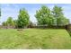 Spacious fenced backyard with lush lawn, mature trees, firepit, and swing set - perfect for outdoor entertaining at 5631 N Peppereel Way, McCordsville, IN 46055