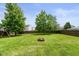 Large backyard features a wood fence, mature shade trees, and a firepit at 5631 N Peppereel Way, McCordsville, IN 46055
