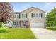 Charming two-story home featuring green shutters, a well-manicured lawn, and an attached two-car garage at 5631 N Peppereel Way, McCordsville, IN 46055