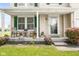 Cozy front porch with seating, flower pots, and a charming entrance to the home at 5631 N Peppereel Way, McCordsville, IN 46055