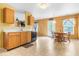 Inviting kitchen and dining area with wooden cabinets, a dishwasher, a table, and chairs set in the room at 5631 N Peppereel Way, McCordsville, IN 46055