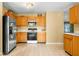 Well-lit kitchen equipped with stainless steel refrigerator and microwave with classic cabinets and plenty of storage at 5631 N Peppereel Way, McCordsville, IN 46055