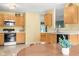 Practical kitchen view showcasing classic cabinets, modern appliances, and a view to dining area at 5631 N Peppereel Way, McCordsville, IN 46055