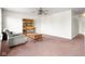 Spacious living room with ceiling fan, featuring a chair, bookshelf, and unique coffee table at 5631 N Peppereel Way, McCordsville, IN 46055