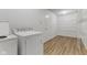 Functional laundry room with washer, dryer, storage shelving, and modern flooring at 5637 Woodland Trace Blvd, Indianapolis, IN 46237