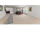 Bright living room features neutral carpeting, a black leather sofa, and staircase access at 5637 Woodland Trace Blvd, Indianapolis, IN 46237