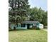 Charming blue home with a lush green lawn and detached two-car garage surrounded by mature trees at 5938 Price Ln, Indianapolis, IN 46254