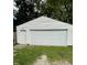 Exterior view of the detached garage with a two-car garage door and a separate access door at 5938 Price Ln, Indianapolis, IN 46254