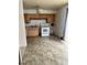 Functional kitchen area with white appliances, wood cabinets and tile floors at 5938 Price Ln, Indianapolis, IN 46254