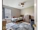 This bedroom features carpeted floors, a ceiling fan, and a large window at 5967 Peregrine Blvd, Indianapolis, IN 46228