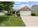 Charming single-story brick home featuring an attached two car garage, a manicured lawn and mature trees at 5967 Peregrine Blvd, Indianapolis, IN 46228