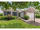 Charming single-story brick home featuring an attached two car garage, a manicured lawn and mature trees at 5967 Peregrine Blvd, Indianapolis, IN 46228