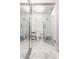 Modern bathroom featuring white tile, glass enclosed shower, mosaic floor tiles, and a sleek, minimalist design at 611 N Park Ave # 104, Indianapolis, IN 46204