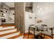 Dining area with a glass table, grey chairs, concrete pillars, wood floors, and stairway access at 611 N Park Ave # 104, Indianapolis, IN 46204