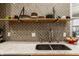 Close-up of kitchen backsplash with open shelving, marble counters, and stainless steel faucet at 611 N Park Ave # 104, Indianapolis, IN 46204