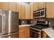 Modern kitchen featuring stainless steel appliances, light wood cabinets, and mosaic tile backsplash at 611 N Park Ave # 104, Indianapolis, IN 46204